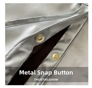 Detail of silver metallic tote bag showing premium magnetic snap closure and suede lining
