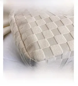 Macro shot showing the texture of a beige woven tote bag with a 3D checkered pattern