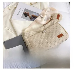 Detail view of beige woven tote bag with adjustable strap and small round coin purse