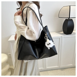 Détail du grand sac cabas noir en similicuir avec charm de monstre blanc en peluche
