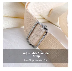 Detailed macro view of off-white woven adjustable shoulder strap with silver metal buckle