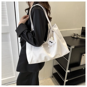 Sac fourre-tout blanc minimaliste avec charme en peluche dans un cadre de bureau