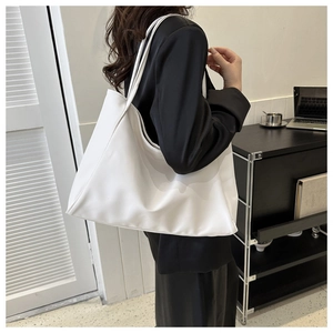 Grand sac cabas blanc minimaliste porté par un mannequin dans un décor de bureau moderne