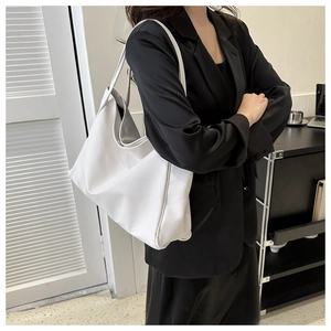 Detailed view of the white large-capacity tote bag worn on shoulder by a model