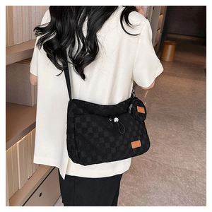 Close-up of black checkered tote bag with a matching round coin purse and wide nylon strap