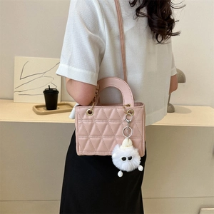 Pink quilted crossbody bag with plush charm shown worn by model in a modern lifestyle setting