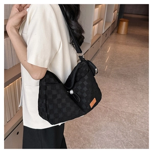 Close-up of black checkerboard canvas tote bag with a matching small coin purse detail