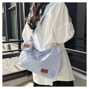 Detail view of light blue textured tote bag with detachable pouch and drawstring closure
