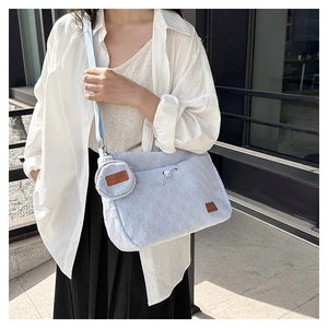 Detail view of light blue woven canvas shoulder bag with matching round coin purse charm