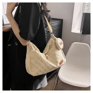 Detail of cream checkered tote bag with a small round pouch and adjustable strap