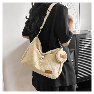 Detail view of beige checkerboard tote bag with a matching round coin purse on a model