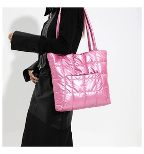 Sac fourre-tout matelassé rose brillant porté par un mannequin avec grand compartiment