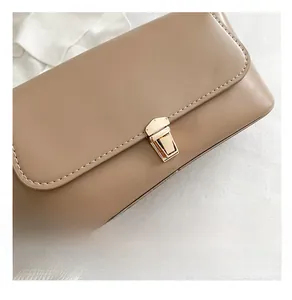 Close-up of premium gold buckle and neat stitching on a khaki leather underarm bag