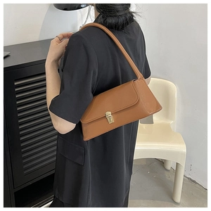 Rear view of model wearing a vintage brown leather baguette bag with gold buckle clasp