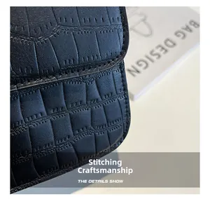 Primer plano del bolso de piel sintética negra con textura de cocodrilo y costuras finas