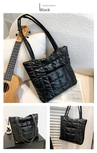 Detail of black quilted tote bag showing high-gloss nylon texture and dual shoulder straps