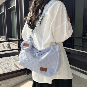 Minimalist light blue crossbody bag with checkered texture and small round coin purse charm