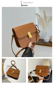 Detalle del bolso bandolera marrón vintage con piel grabada de cocodrilo y hebilla dorada