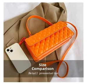 Size comparison of orange quilted crossbody bag next to a white smartphone on tan fabric