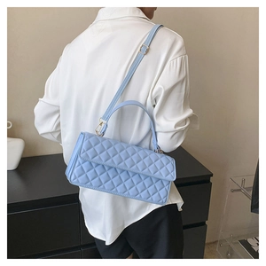 Close-up of light blue quilted shoulder bag with gold hardware and PU leather texture