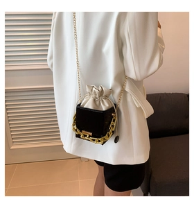 Mini crossbody bag with gold chain decoration and white drawstring insert on a model