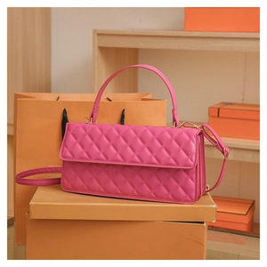 Detailed macro view of quilted magenta handbag featuring gold hardware and elegant handle