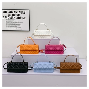 Multiple colorful quilted small square handbags shown in an elegant tiered display