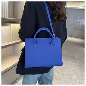 Dettaglio borsa tote blu elettrico in pelle saffiano con accessori metallici oro