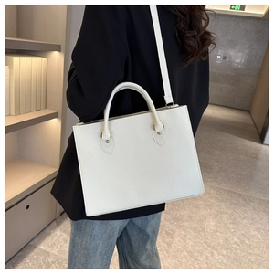 Dettaglio della borsa tote bianca minimalista con trama in pelle e hardware dorato