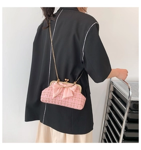 Détail du sac bandoulière en tweed rose avec fermoir doré et un grand nœud décoratif