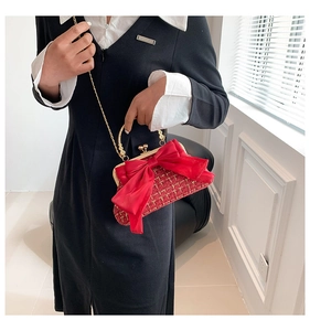 Détail du sac en tweed rouge avec noeud en soie et bandoulière chaîne dorée