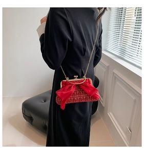 Détail du sac en tweed rouge avec chaîne dorée et grand nœud décoratif en satin