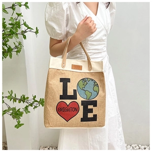 Detail of the LOVE theme print and leather handles on a linen canvas tote bag