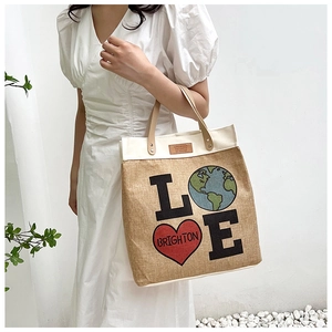Detail of burlap tote bag featuring 'LOVE' print with earth icon and Brighton heart logo