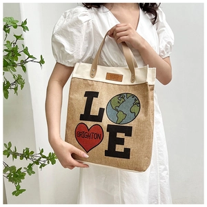 Close-up of jute tote bag featuring LOVE Earth print and durable leather handles