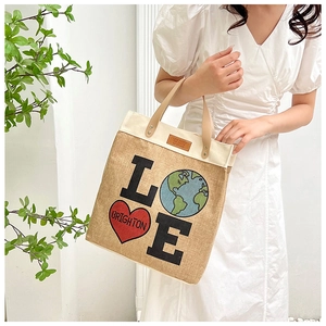 Detail of jute tote bag with LOVE graphics, leather handles and reinforced metal rivets