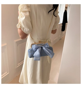 Détail du sac chaîne en tweed bleu avec grand nœud en mousseline et cadre doré