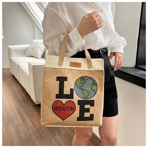 Detail of canvas tote bag with LOVE earth graphic and brown leather handle strap