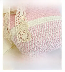 Vista dettagliata della borsa a cesto intrecciata rosa e bianca con pizzo floreale