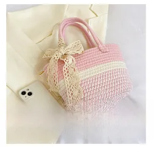 Dettaglio della borsa intrecciata a righe rosa e bianche con fiocco in pizzo crema
