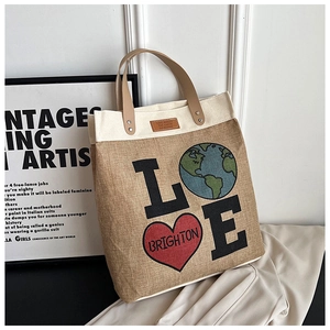 Close-up of jute tote bag with LOVE heart print and brown leather handles