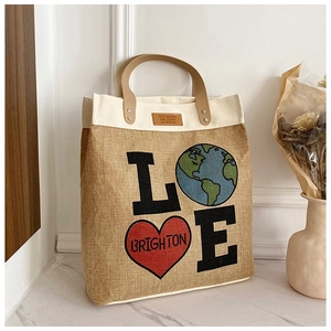 Detail of jute tote bag with LOVE globe print and reinforced brown leather handles