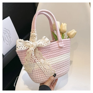 Dettaglio borsa a cesto intrecciata rosa e bianca con grande fiocco in pizzo e tulipani