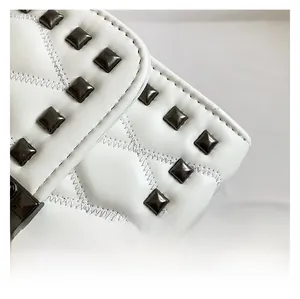 Detail of white quilted leather bag featuring iconic black square metal pyramid studs
