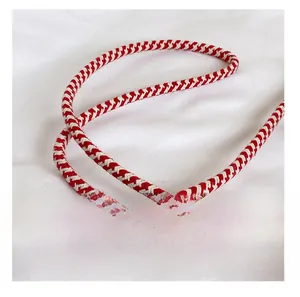 Détail de la bandoulière tressée rouge et blanc avec une texture de fibre épaisse