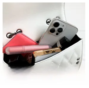 Internal view of white quilted crossbody bag showing smartphone and cosmetics storage