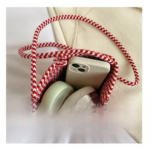 Vue de dessus du mini sac tressé montrant sa capacité pour smartphone et maquillage