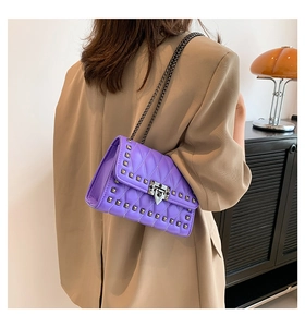 Detail of purple quilted leather crossbody bag with silver studs and chain strap