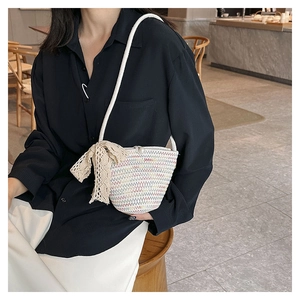 Dettaglio mini borsa a secchiello intrecciata arcobaleno con chiusura a perla e fiocco