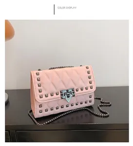 Detailed view of pink quilted leather shoulder bag with gunmetal pyramid studs and chain